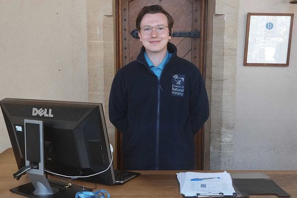 A member of Museum staff wearing a navy blue fleece with a white museum logo